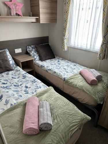a room with two beds with towels on them at LOIRE in Skegness