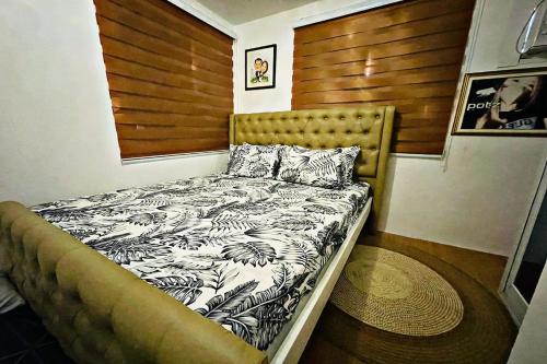 Shiella's Staycation House Cabanatuan في كاباناتوان: سرير في غرفة مع اللوح الأمامي الخشبي