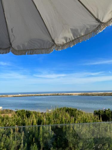 a view of the ocean from a beach umbrella at The Beach House Roof in Vila Nova De Cacela