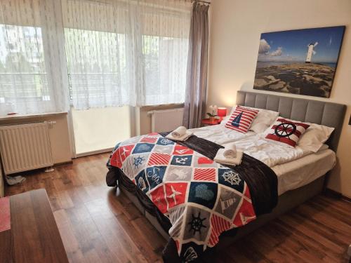 a bedroom with a bed with a quilt on it at Apartament TRZY POMOSTY Villa Mistral in Świnoujście