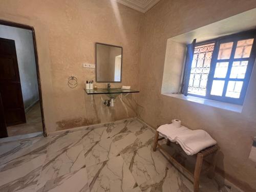 ein Bad mit Marmorboden und einem Waschbecken in der Unterkunft Escapade famille - vue panoramique et piscine privée in Aït Ghemat