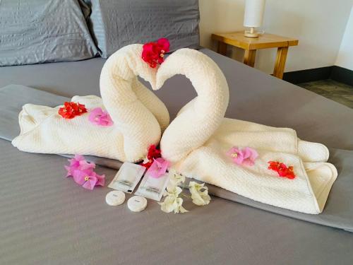 a couple of towels and flowers on a bed at Buona Vita resort in Panglao