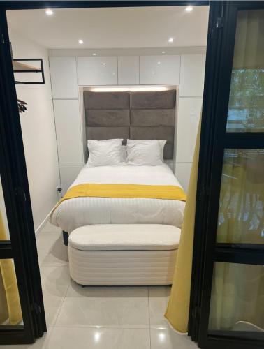 une chambre avec un lit avec une couverture jaune et blanche dans l'établissement Deux. Pièces face à la scène., à Neuilly-sur-Seine