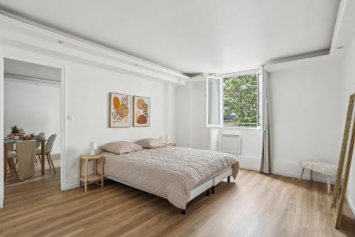 une chambre blanche avec un lit et une table dans l'établissement Aubervilliers Modern flat in for 4 peoples, à Aubervilliers