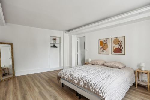 une chambre blanche avec un lit et un miroir dans l'établissement Aubervilliers Modern flat in for 4 peoples, à Aubervilliers