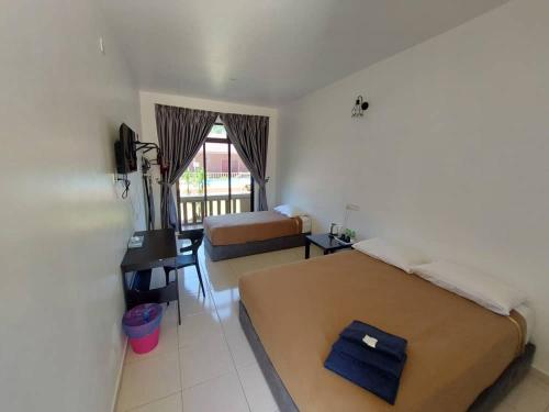 a hotel room with a bed and a desk and a bedroom at Cempaka Beach Resort in Kuantan