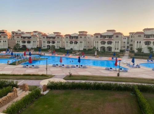 a large swimming pool in front of a large building at Lasirena north coast Chalet With Roof , 3 rooms in Zāwiyat ‘Abd al Mun‘im