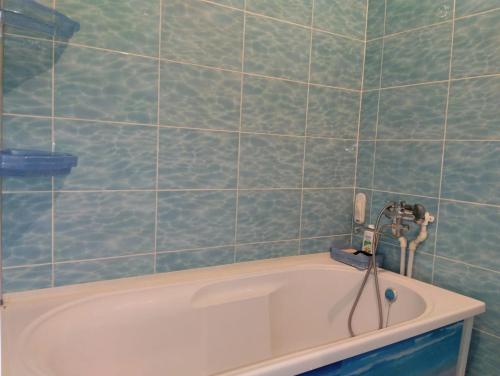 a bath tub with a faucet in a bathroom at Квартира in Aktobe