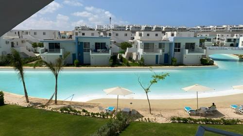 a view of a resort with a pool and a beach at Fouka bay chalet at north coast, Egypt in Marsa Matruh