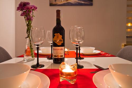 uma garrafa de vinho sentada numa mesa com copos em Apartament City Center Wierch 6 em Krynica-Zdrój