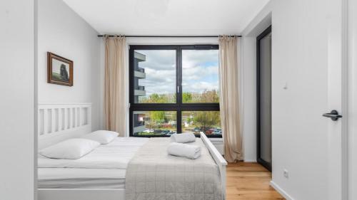 1 Schlafzimmer mit 2 Betten und einem großen Fenster in der Unterkunft Family Apartments Portova in Gdynia