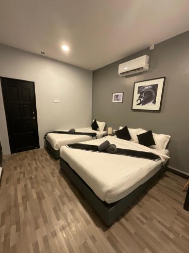a bedroom with two beds and a air conditioner at The Sky Inn in Kuantan