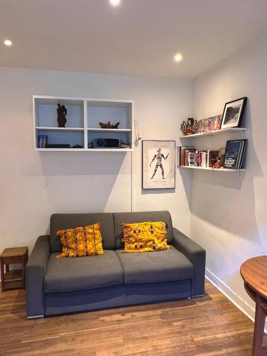 un salon avec un canapé bleu avec des coussins jaunes dans l'établissement Charming Montmartre Studio, à Paris