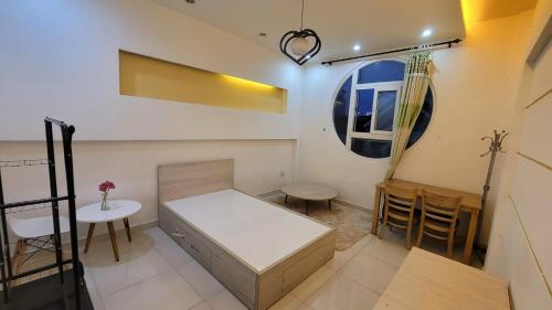 a small room with a bed and a table at Homestay Fairy's House in Ho Chi Minh City
