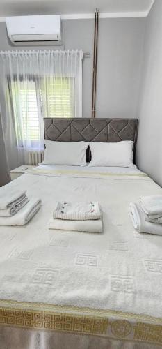 een groot wit bed met 2 handdoeken erop bij Apartments Popovic in Kotor