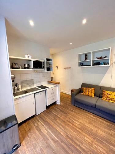 une cuisine et un salon avec un canapé dans une pièce dans l'établissement Charming Montmartre Studio, à Paris