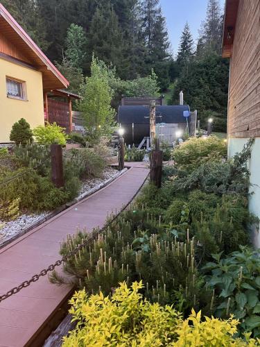 a walkway in a garden next to a building at Penzión Pod Guglom in Mlynky 