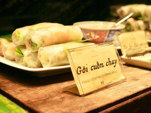 a plate of food on a wooden table with a sign at Amanaki Saigon Boutique Hotel in Ho Chi Minh City