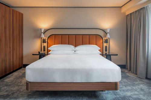 - une chambre avec un grand lit blanc et deux lampes dans l'établissement Hilton Paris La Défense, à Puteaux