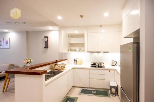 a kitchen with white cabinets and a counter top at The Gold View D4 - Canhogiatot24h in Ho Chi Minh City