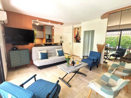 - un salon avec un canapé et des fauteuils bleus dans l'établissement Magnifique et grand studio, piscine, parking, très calme résidence de standing, à Cannes