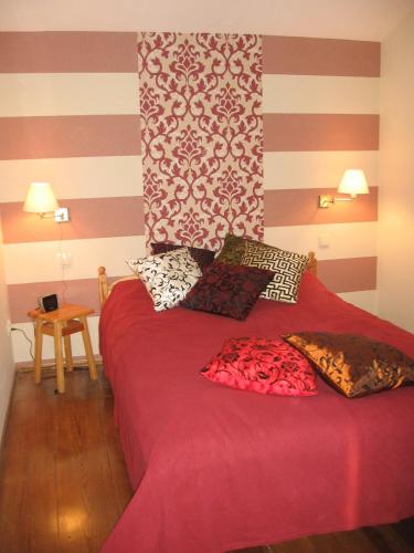 a bedroom with a red bed with pillows on it at Dom na Jutrzenki in Augustów