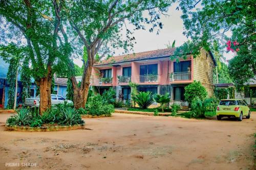 a building with cars parked in front of it at PRIMESHADE GUESTHOUSE in Malindi