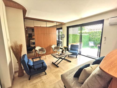 un salon avec un canapé, des chaises et une table dans l'établissement Magnifique et grand studio, piscine, parking, très calme résidence de standing, à Cannes