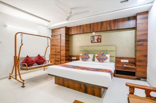 FabHotel Ratna Palace في أحمد آباد: غرفة نوم بسرير كبير ومقعد