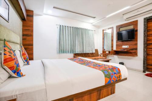 a hotel room with a bed and a tv at FabHotel Ratna Palace in Ahmedabad