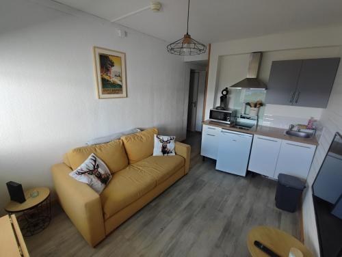 a living room with a couch and a kitchen at Appartement avec belle vue sur montagne in Égat