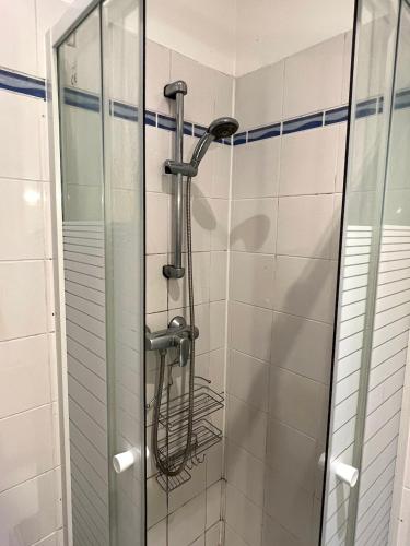 une douche avec pommeau de douche dans une salle de bain dans l'établissement Charming Montmartre Studio, à Paris
