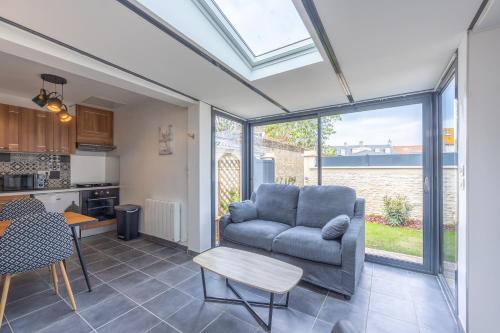 un salon avec un canapé et une table dans l'établissement La Tanière des Oursons - proche de la plage, à Courseulles-sur-Mer