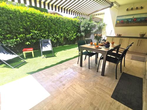 un patio avec une table et des chaises dans une cour dans l'établissement Magnifique et grand studio, piscine, parking, très calme résidence de standing, à Cannes