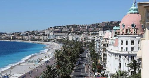 une vue d'une plage avec des bâtiments et l'océan dans l'établissement Residence Akantha, à Nice