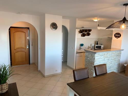 a kitchen and dining room with a table and chairs at T2 clim 54m2, 17m2 de terrasse très belle vue mer in LʼÎle-Rousse