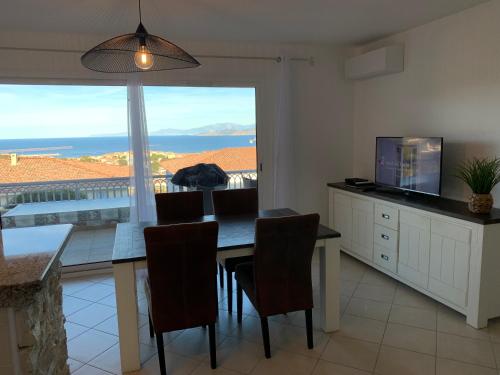 a dining room with a table and a view of the ocean at T2 clim 54m2, 17m2 de terrasse très belle vue mer in LʼÎle-Rousse