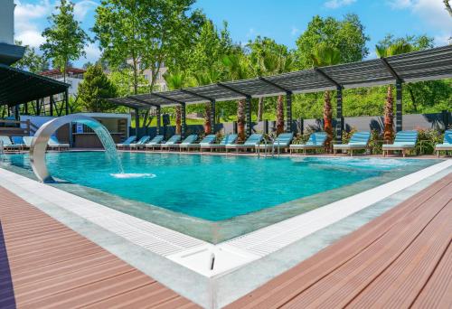 una piscina con sedie e fontana di Vital Thermal Hotel & SPA a Termal