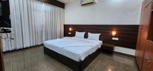 a bedroom with a bed with a wooden headboard at Gracias Villa in Panaji