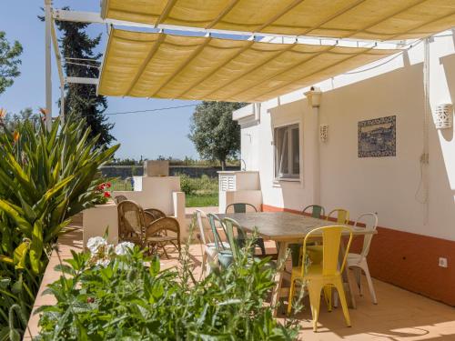 a patio with a table and chairs under awning at Quinta da Foz - Vivenda Amélia in Foz