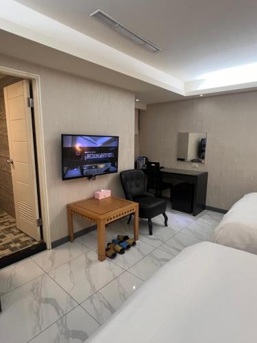 Pokój hotelowy z łóżkiem, biurkiem i telewizorem w obiekcie Ya Dou Hotel w Tajpej