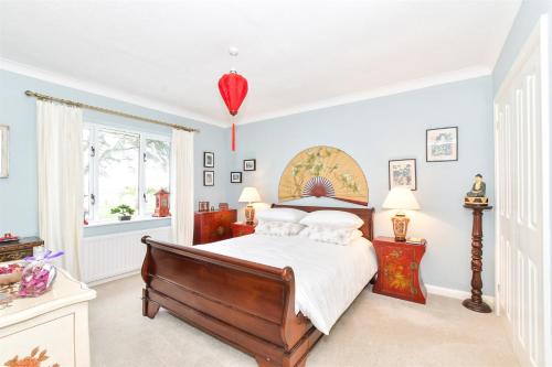 a bedroom with a bed and a window at Stay at 'The Elms' in tranquil Church Norton, Selsey - Ground floor bedroom, own private bathroom, quiet beach, 2 acre garden by the sea, on edge of wildlife nature reserve in Selsey