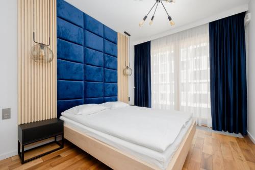 ein Schlafzimmer mit einer Wand mit blauen Akzenten und einem Bett in der Unterkunft Cozy Apartments with Parking in the 19th District by Renters in Warschau