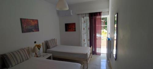Habitación con cama, silla y ventana en Top Holidays Apartments, en La Canea