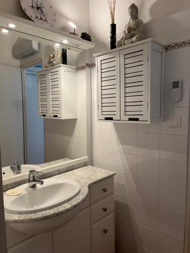 une salle de bain avec un lavabo et un miroir dans l'établissement T2 avec piscine à 400m de la plage, à Saint-Jean-de-Monts