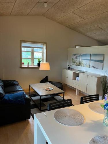 - un salon avec un canapé et une table dans l'établissement Skøn lejlighed til 4 personer, à Ansager