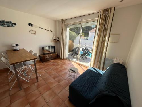 un salon avec un canapé, une table et une télévision dans l'établissement T2 avec piscine à 400m de la plage, à Saint-Jean-de-Monts