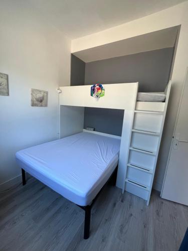 Ce lit superposé se trouve dans un dortoir doté d'un matelas bleu. dans l'établissement T2 avec piscine à 400m de la plage, à Saint-Jean-de-Monts