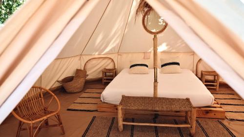 een tent met een bed en een spiegel bij HolaCamp Vendrell in Comarruga