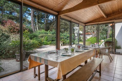 une salle à manger extérieure avec une table et des bancs dans l'établissement Maison avec jardin pour 6 à St Brévin L’Océan, à Saint-Brévin-les-Pins
